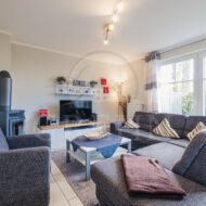 modern eingerichtetes Wohnzimmer mit Couch und Glastüren zur Terrasse