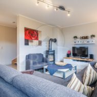 modern eingerichtetes Wohnzimmer mit Couch und Kamin